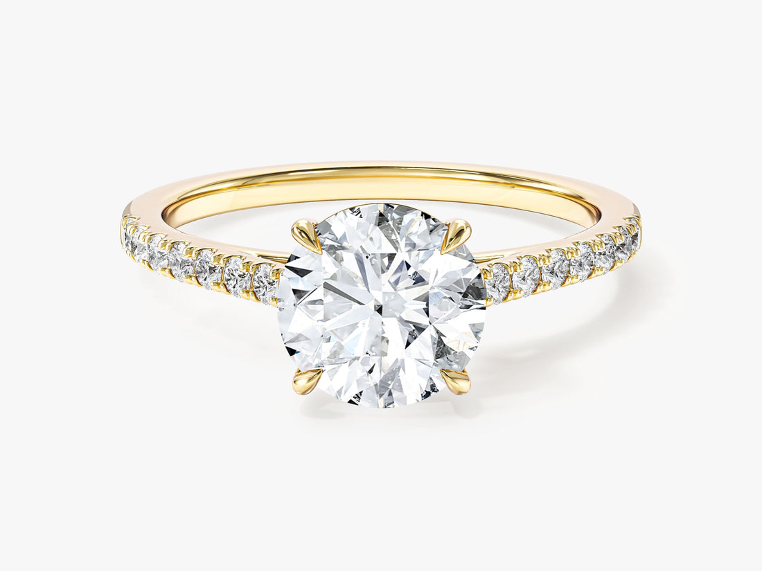 Round cut moissanite cathedral engagement ring with pave band in 14K yellow gold, front view