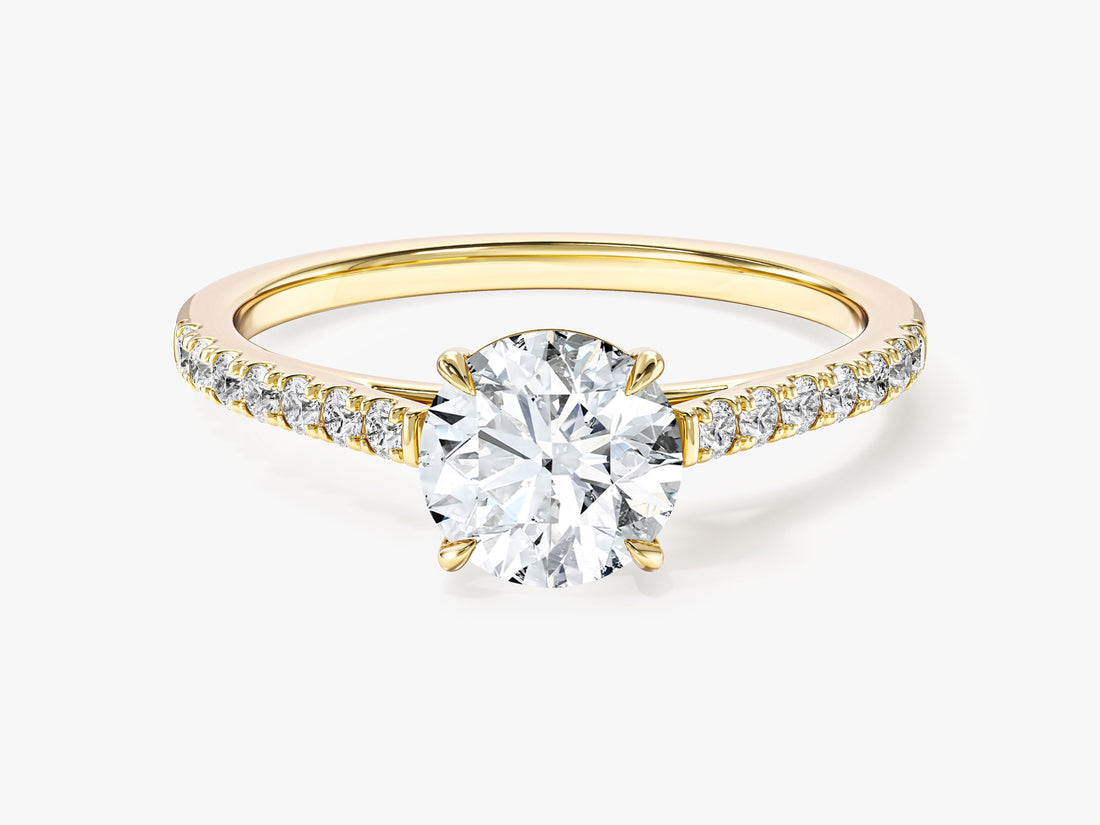 Round brilliant moissanite four claw pave solitaire engagement ring in 14K yellow gold, front view