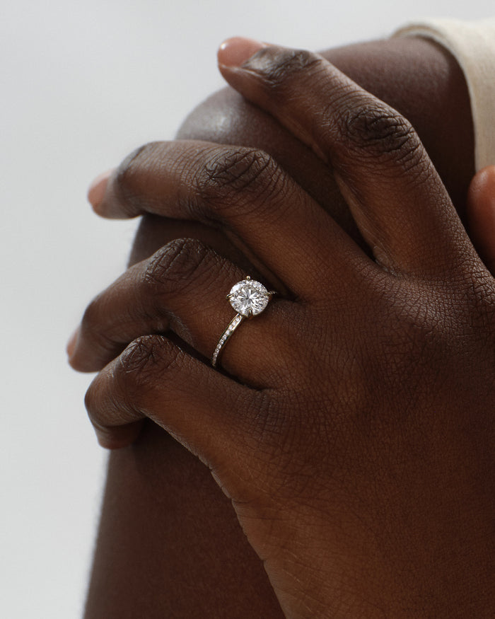 Round lab grown diamond channel set ring in white gold worn on the hand at the shoulder