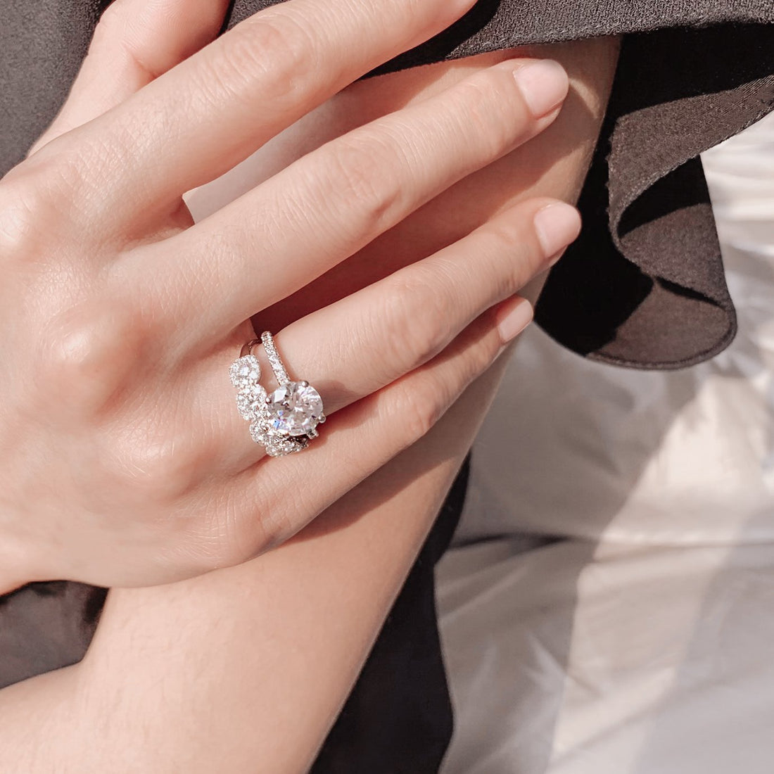 Round brilliant moissanite four claw engagement ring on a full pave shank in white gold