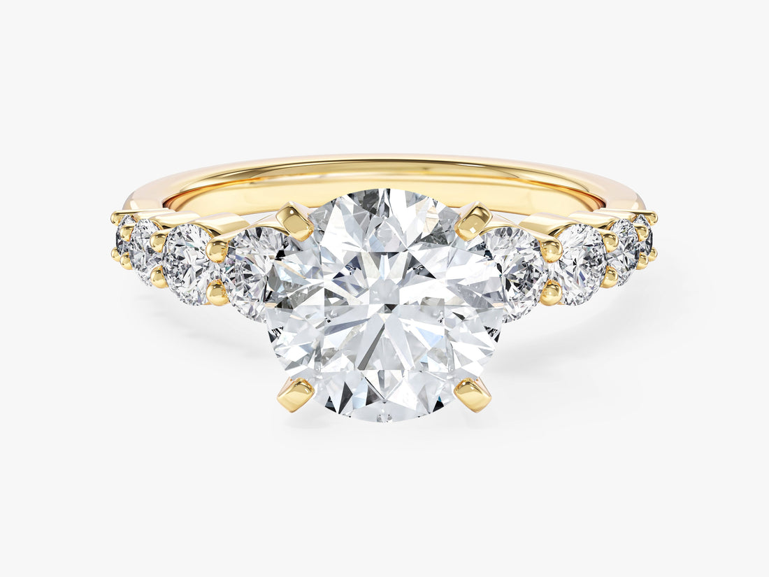 Round moissanite engagement ring with graduated shared prong side stones in 14K yellow gold, front view