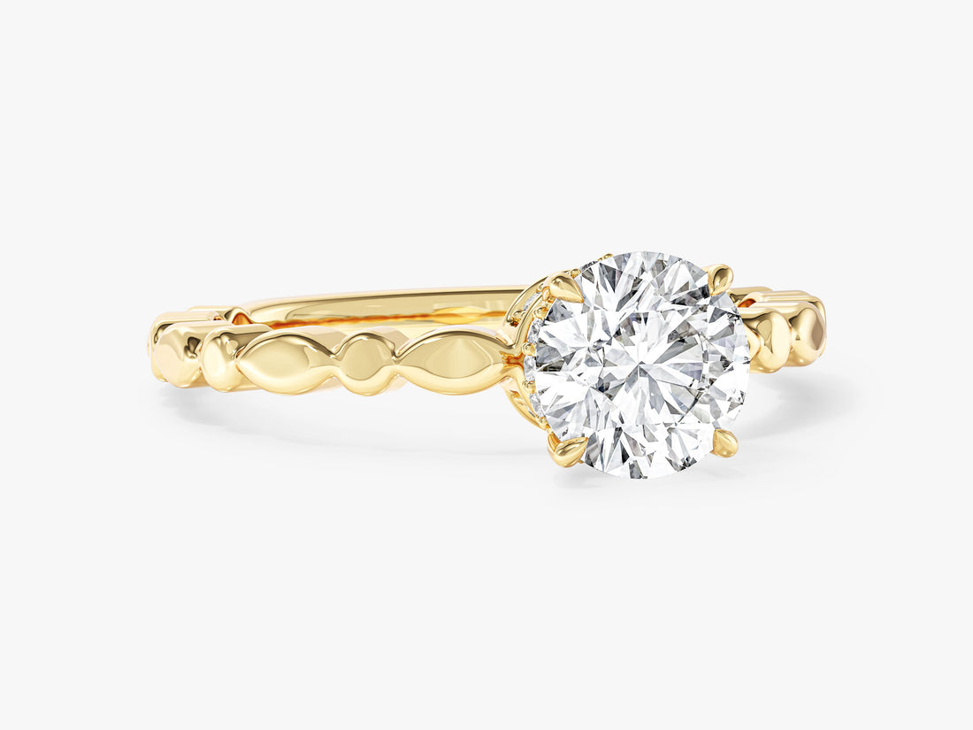 Round moissanite hidden halo engagement ring with sculpted bead and link band in 14K yellow gold, angled view