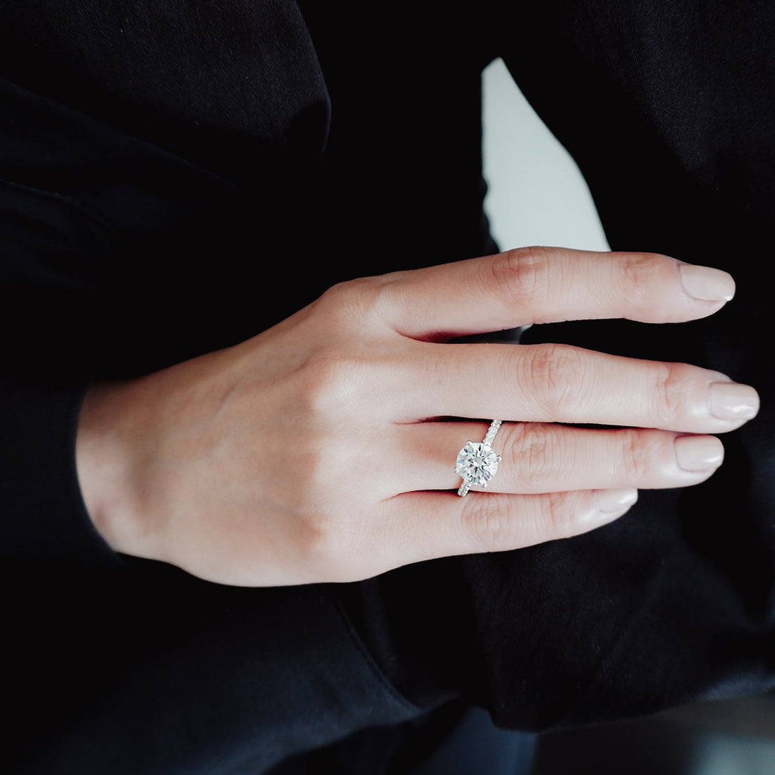 Round brilliant moissanite hidden halo engagement ring on a French pave shank in white gold