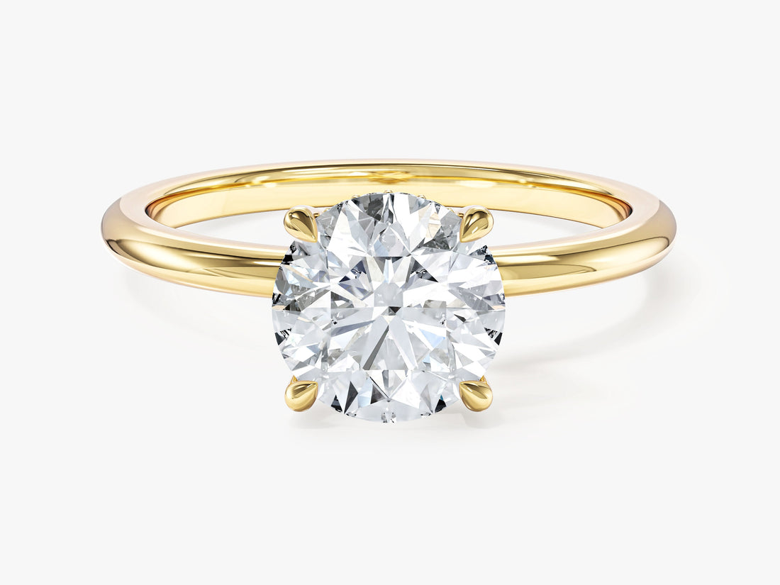 Round brilliant moissanite four claw hidden halo engagement ring on a thin band in yellow gold, front view