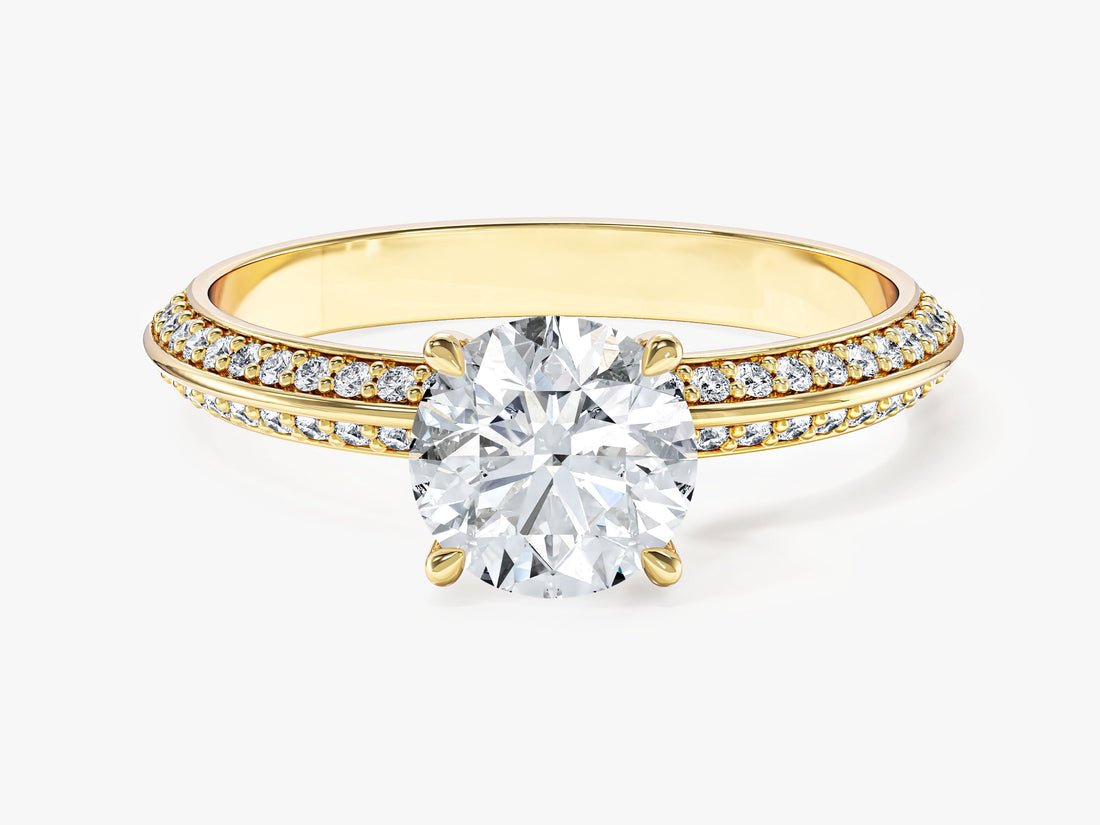 Round moissanite four claw solitaire engagement ring on a pave knife edge band in 14K yellow gold, front view