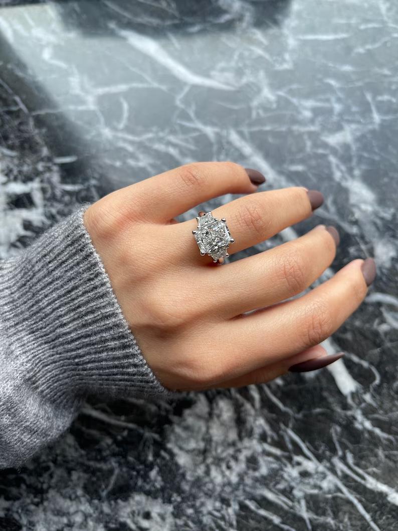 Large radiant cut moissanite three stone engagement ring with trapezoid sides in white gold