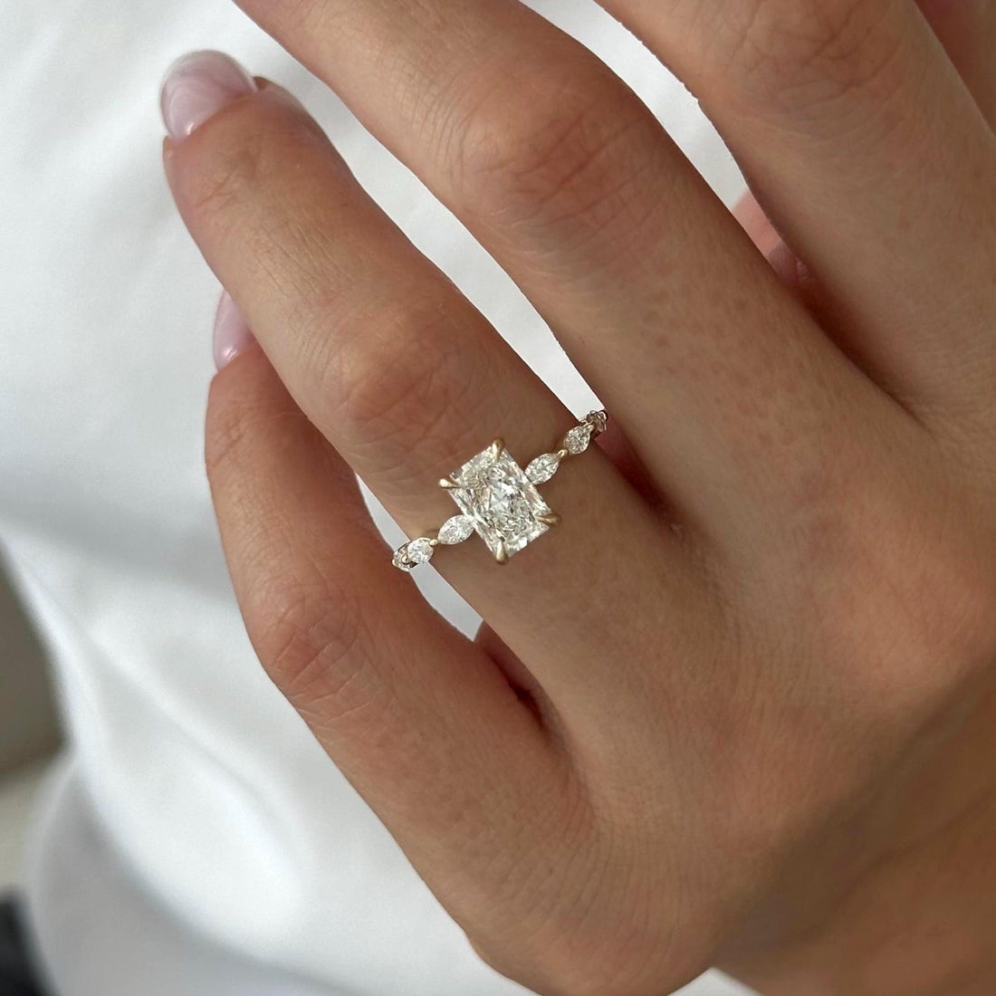Radiant cut moissanite engagement ring with marquise and round accent band in yellow gold