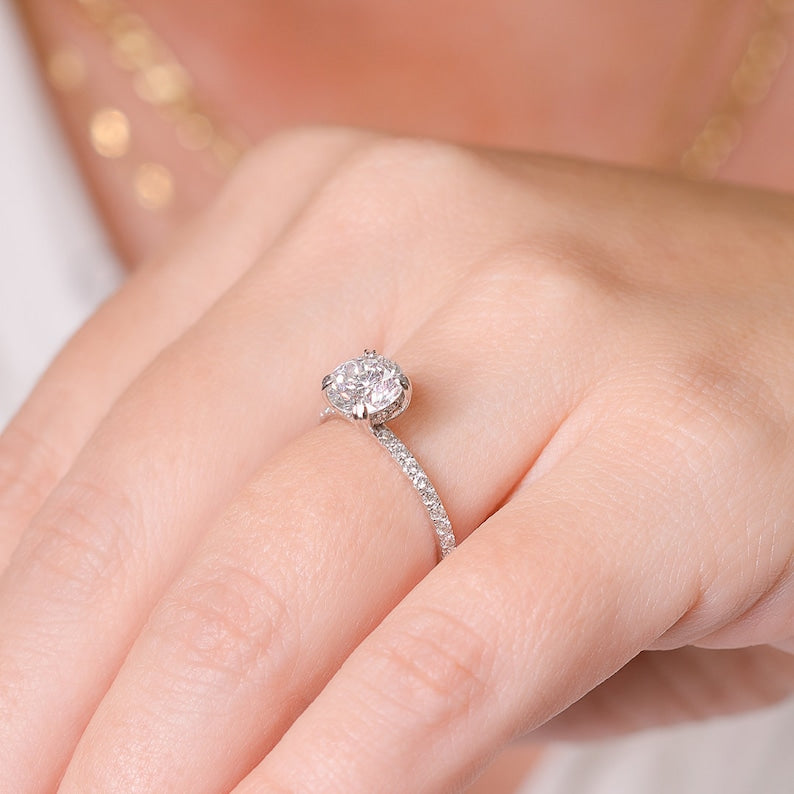 Round brilliant moissanite petite hidden halo engagement ring on a fine pave shank in white gold