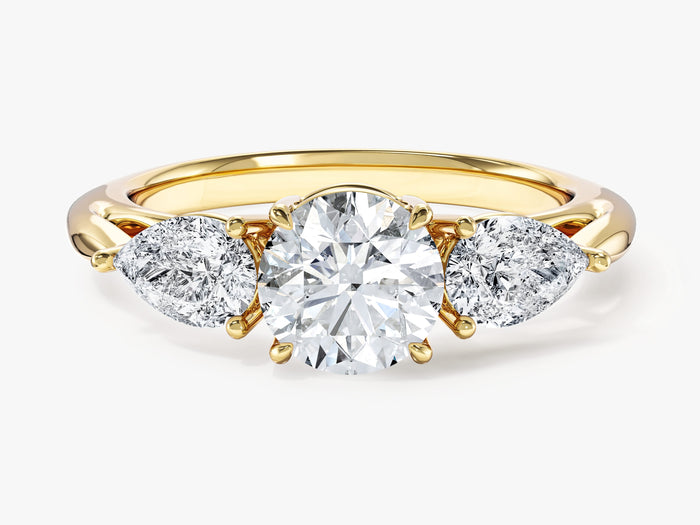 Round lab grown diamond three stone engagement ring with pear side stones in yellow gold, front view