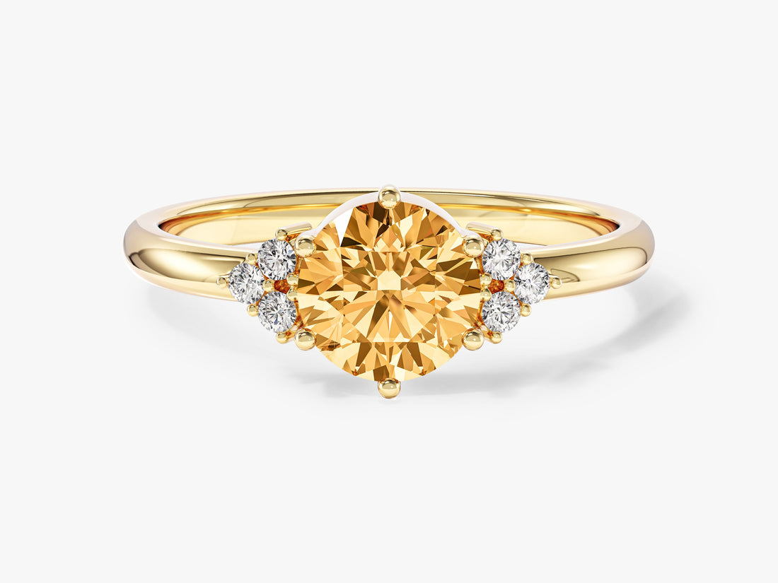 Round moissanite six prong engagement ring setting with trio cluster accents in 14K yellow gold, orange display stone