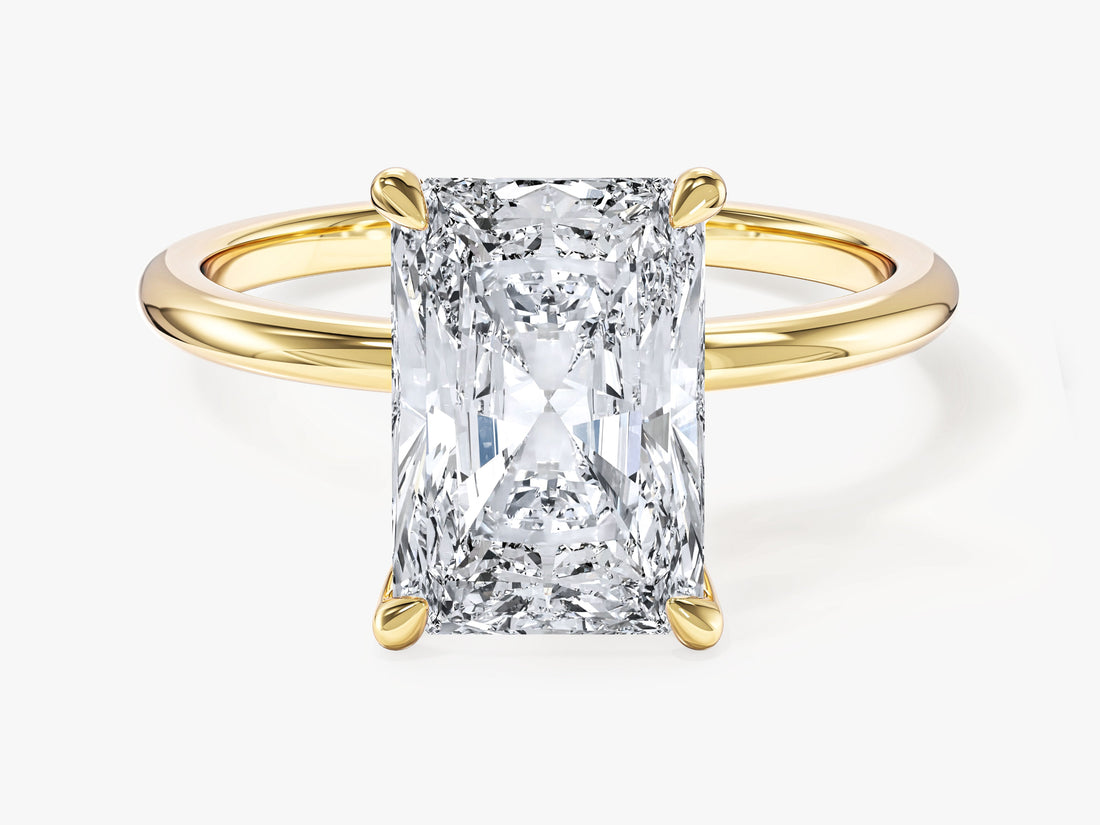 Large elongated radiant cut moissanite four claw solitaire engagement ring in yellow gold, front view