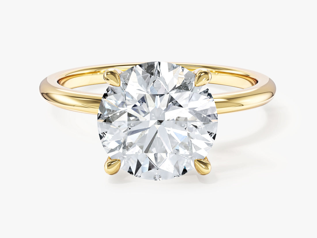 Round brilliant moissanite solitaire engagement ring on a slim polished band in yellow gold, front view