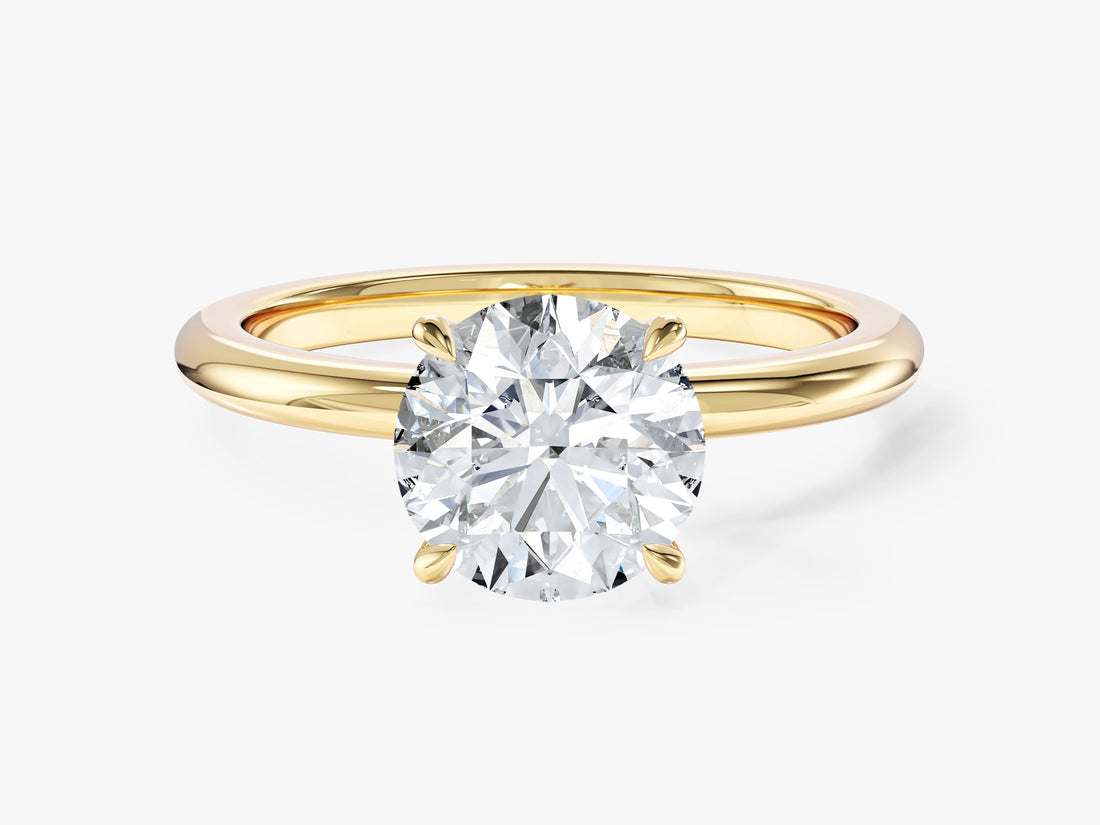 Round moissanite four claw solitaire engagement ring on a polished band in 14K yellow gold, front view