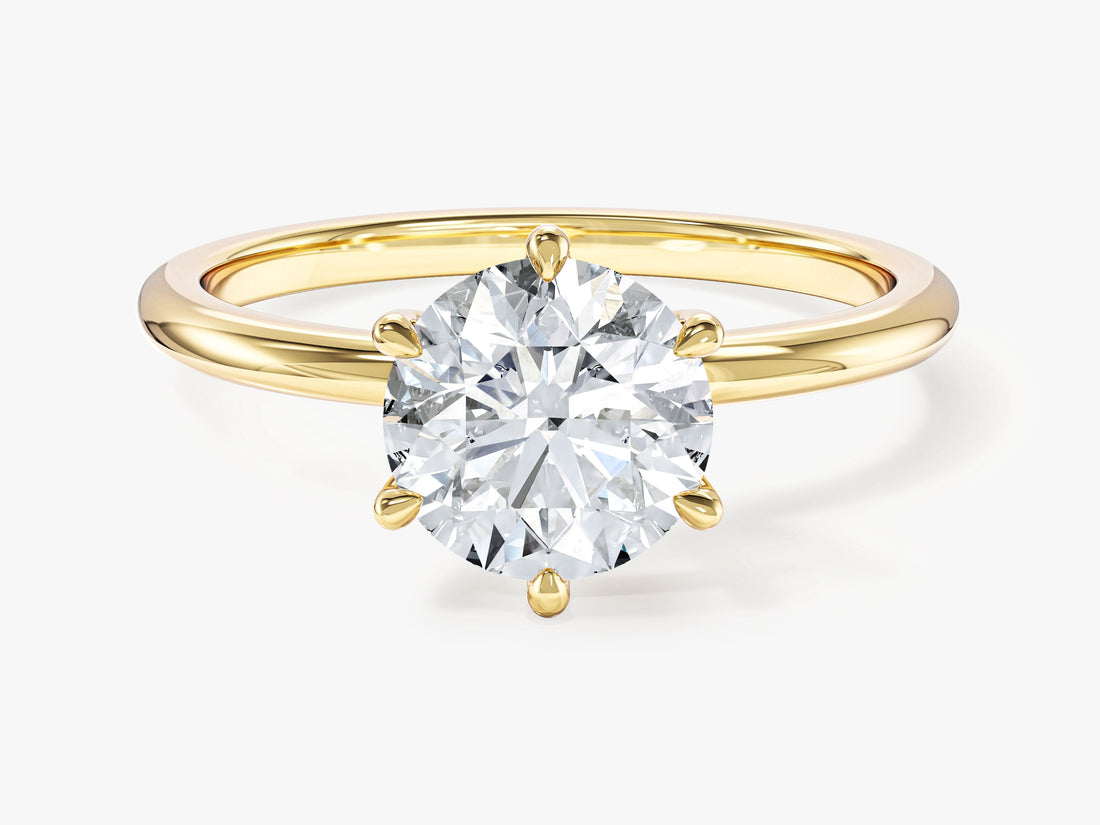 Round lab grown diamond six prong solitaire engagement ring in yellow gold, front view on a light background