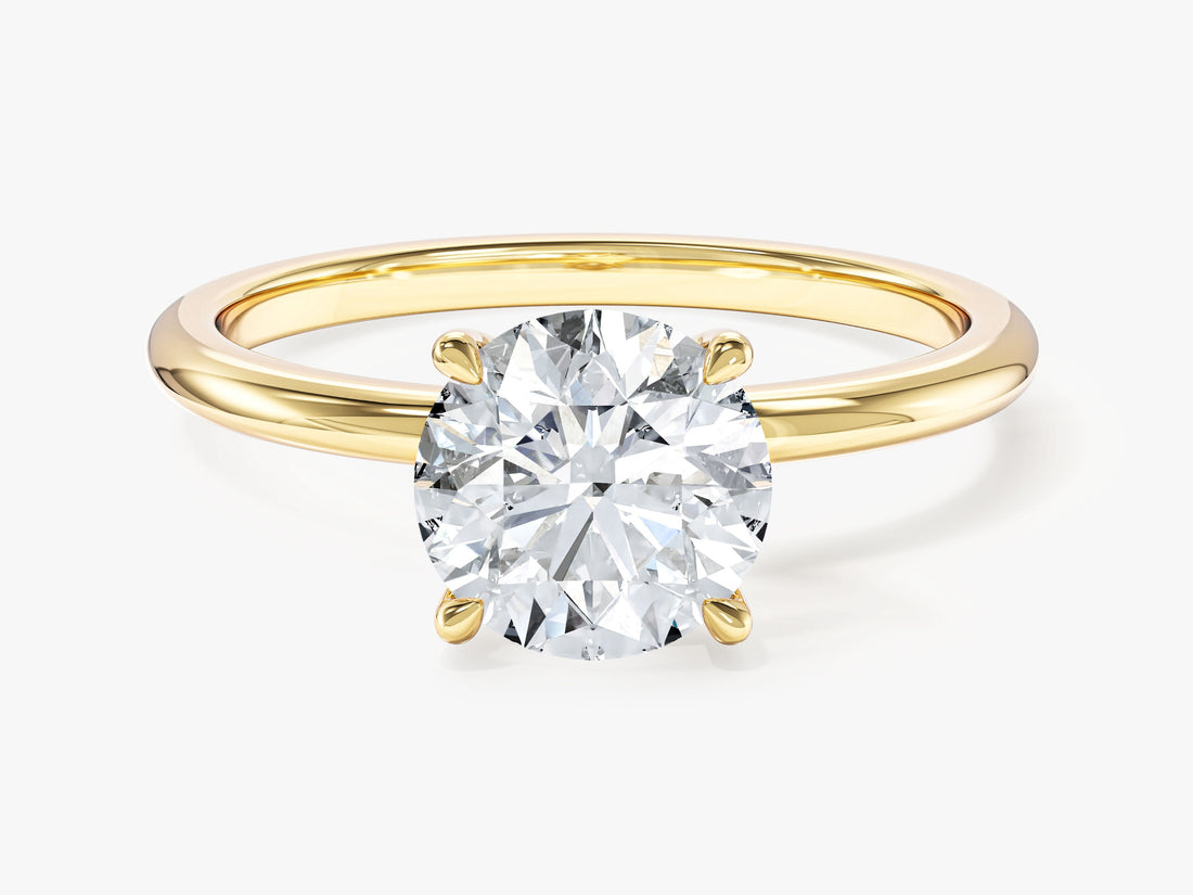 Round lab grown diamond solitaire with four claw basket and plain shank in yellow gold, front view