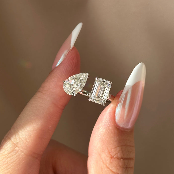 Pear and emerald cut moissanite toi et moi engagement ring on a plain white gold band