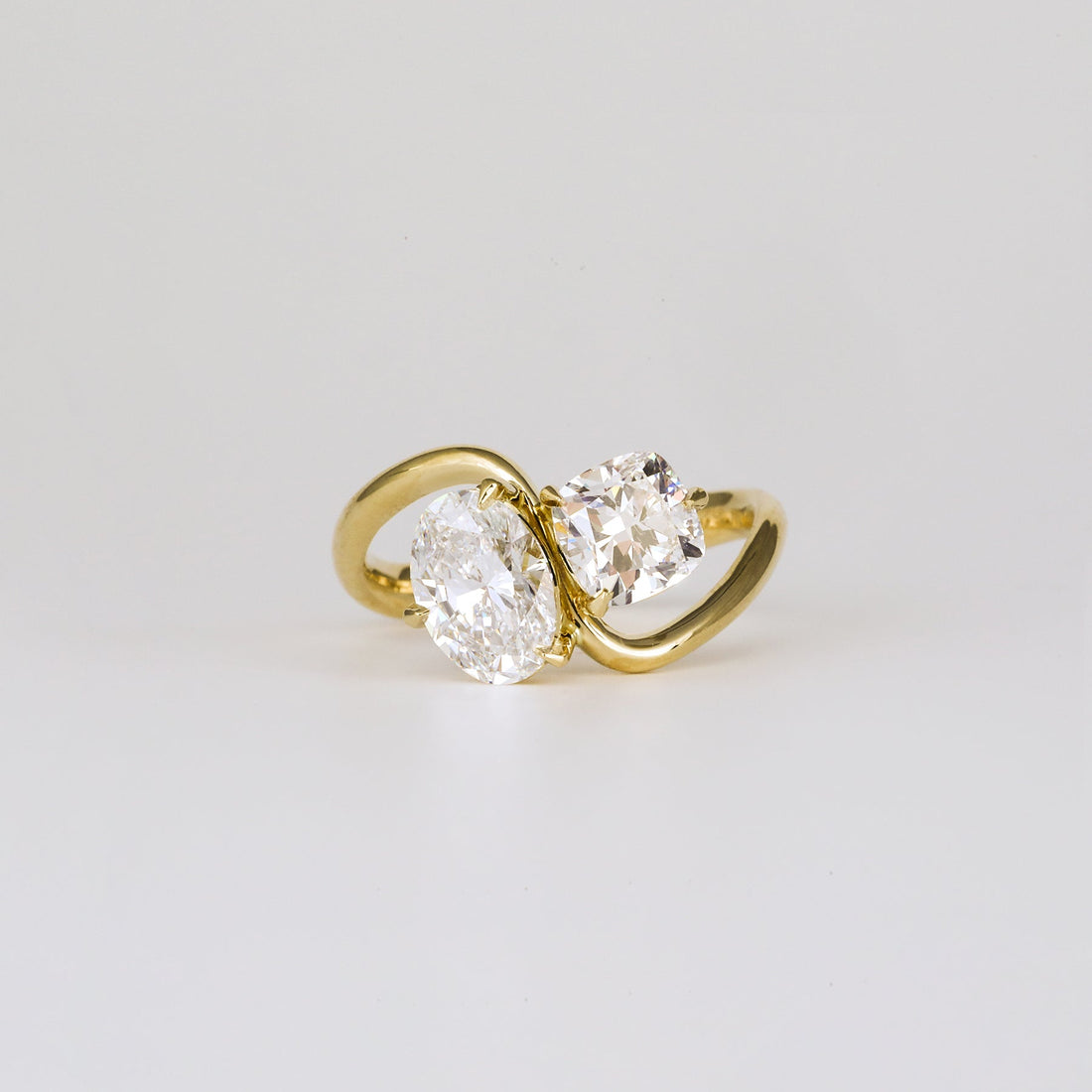 Oval and cushion cut moissanite toi et moi bypass engagement ring in yellow gold