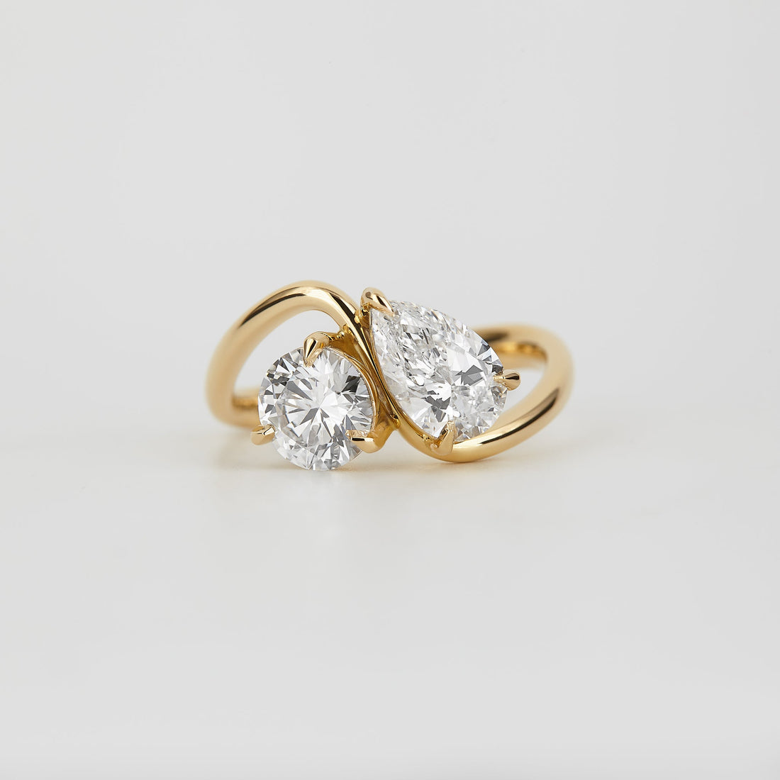 Pear and round moissanite toi et moi bypass engagement ring in yellow gold