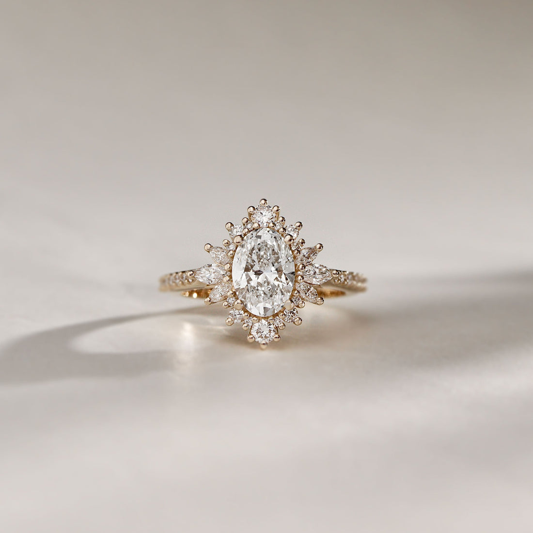 Oval cut lab grown diamond ring with a marquise starburst halo in yellow gold