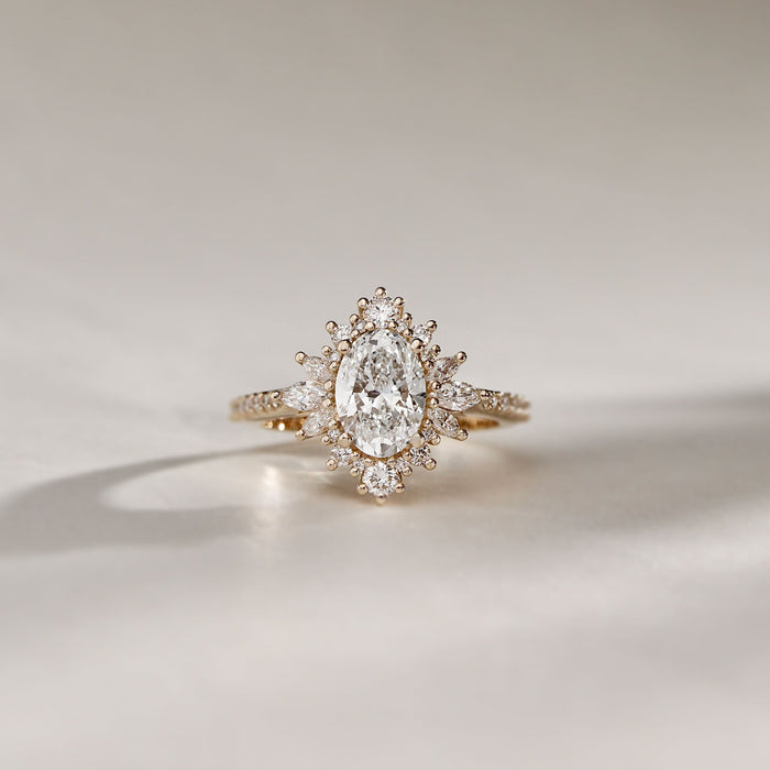 Oval cut lab grown diamond ring with a marquise starburst halo in yellow gold