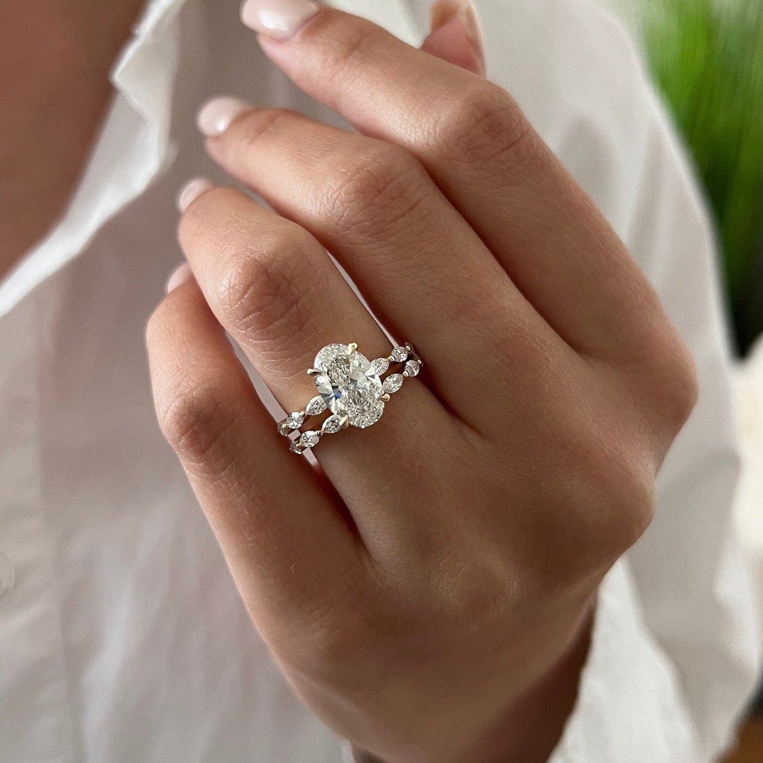 Oval lab grown diamond marquise station bridal set in yellow gold on the hand