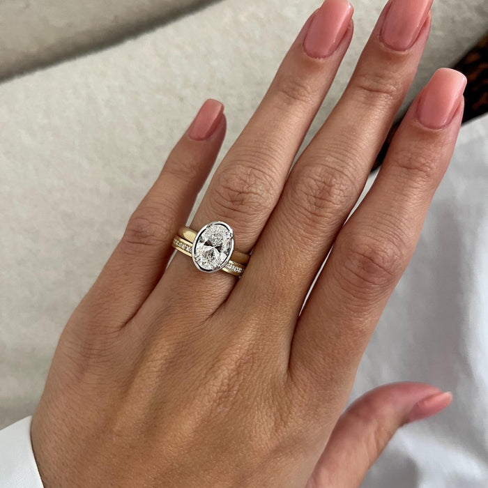 North-south oval moissanite bezel ring and channel set band on the flat hand