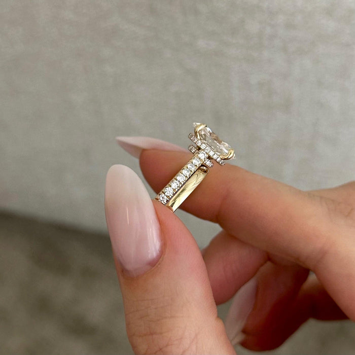 Side view of oval moissanite pave engagement ring and plain band showing the pave gallery