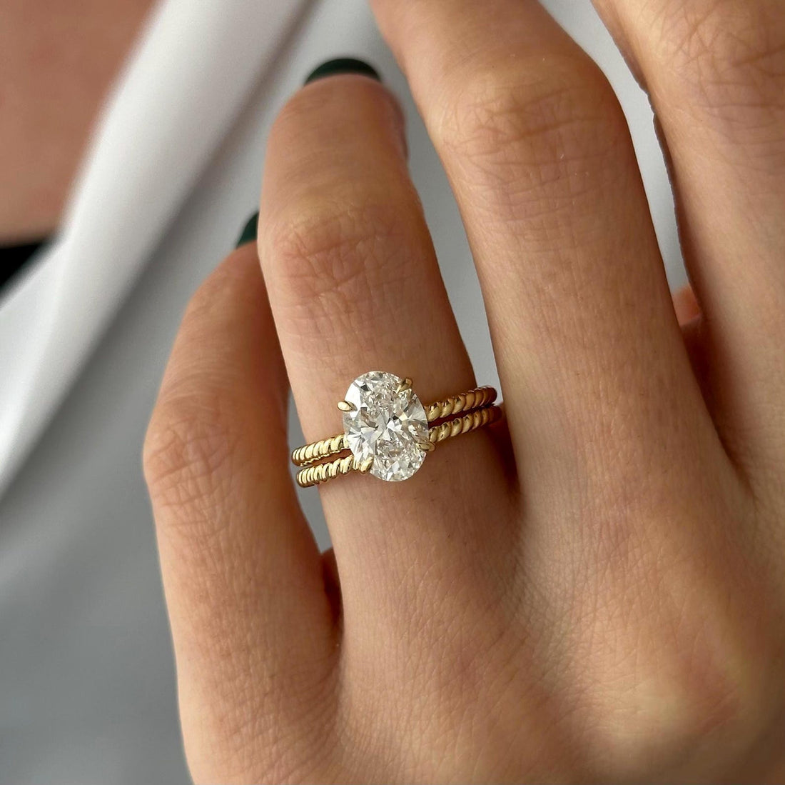 Oval moissanite rope twist bridal set in yellow gold on the hand
