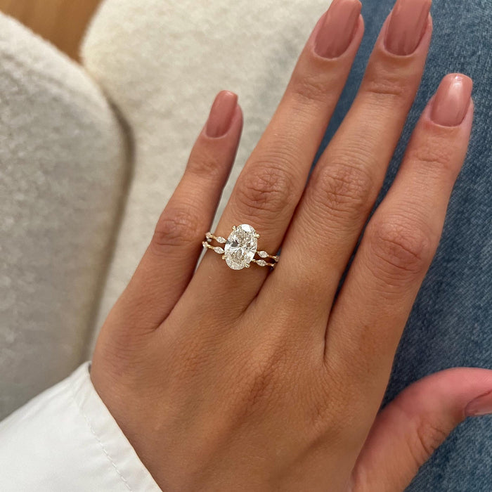 Oval moissanite four-prong ring and dainty marquise accent band, full hand view