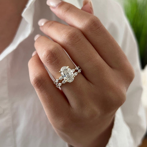 Oval moissanite marquise station bridal set in yellow gold on the hand