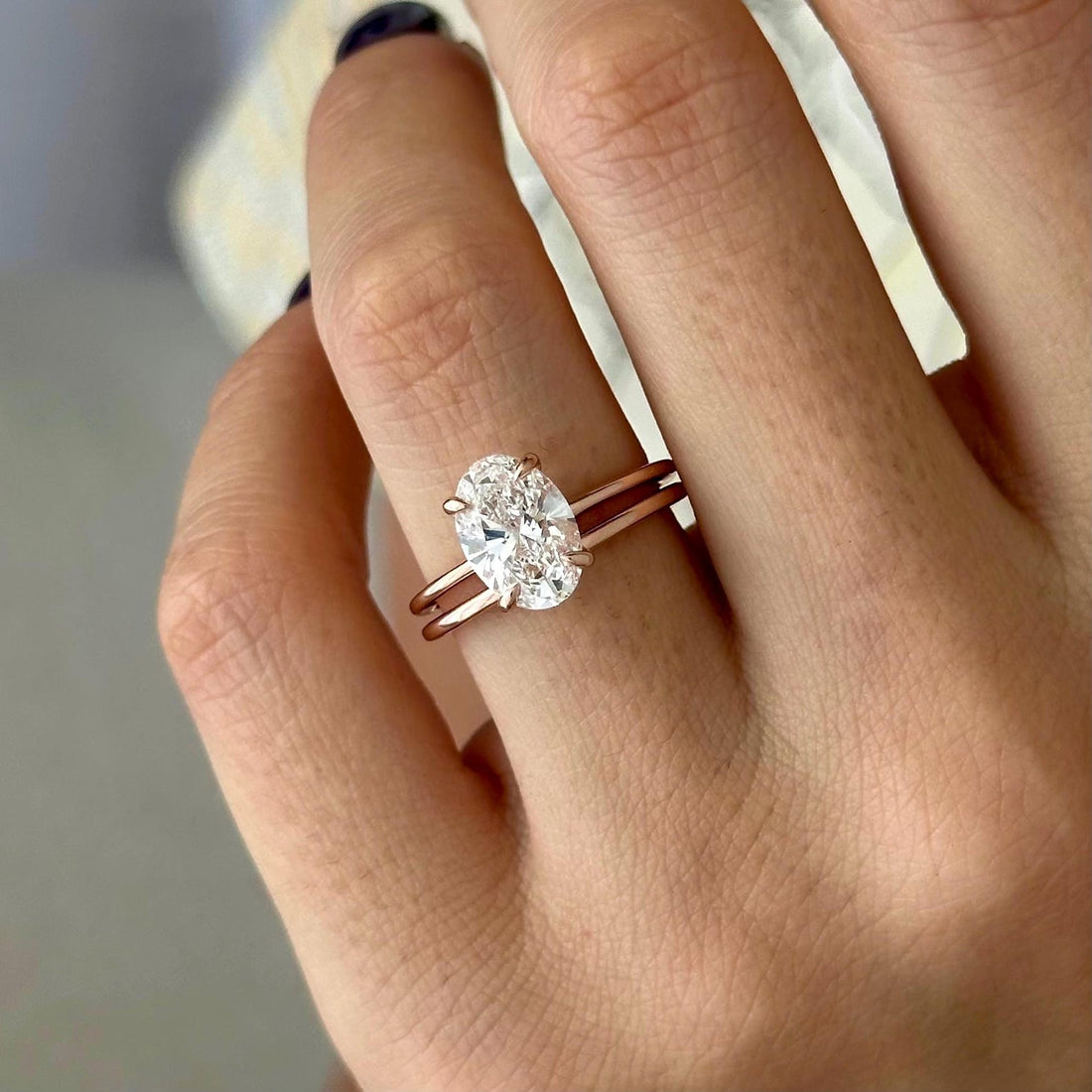Oval moissanite thin solitaire bridal set in rose gold on the hand