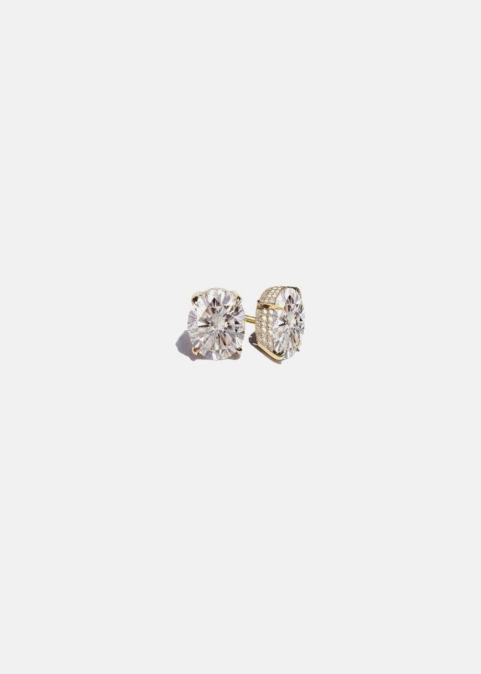 Pair of yellow gold oval lab grown diamond stud earrings in four prong pave basket settings, one earring turned to show the side