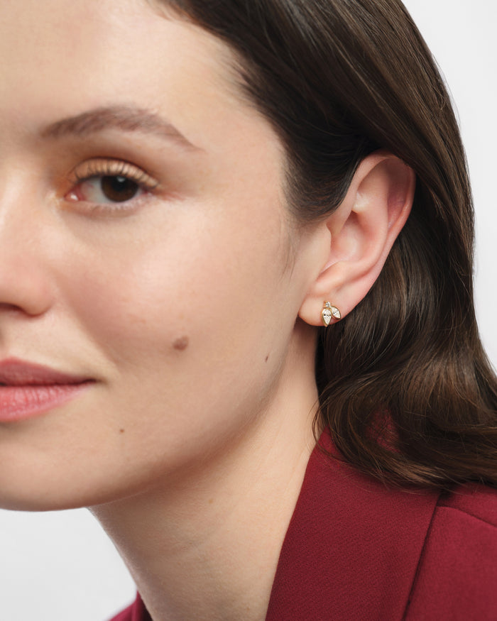 Model wearing pear bezel leaf cluster lab grown diamond stud earrings, close up on the ear