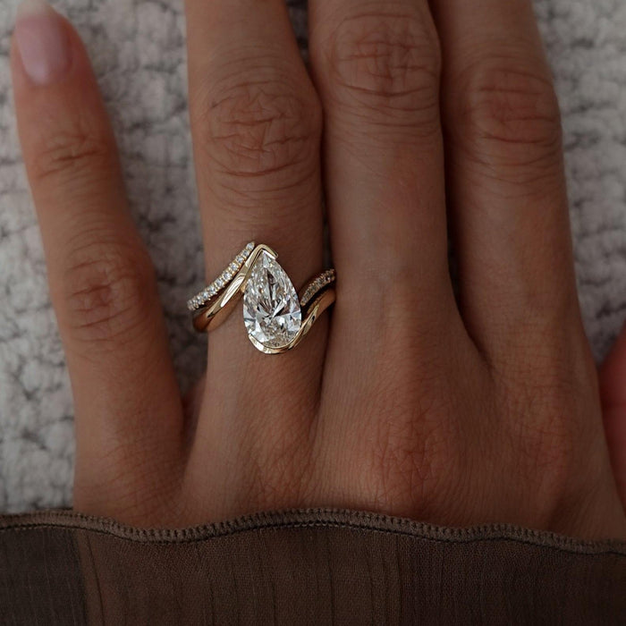 Pear lab grown diamond swirl bridal set with chevron pave band in yellow gold worn on the hand