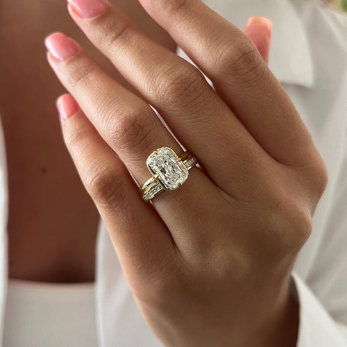 Radiant lab grown diamond claw bezel bridal set in yellow gold worn on the hand