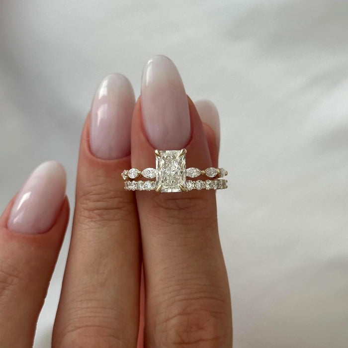 Front view of elongated radiant lab grown diamond ring with marquise side stones above a round stone band