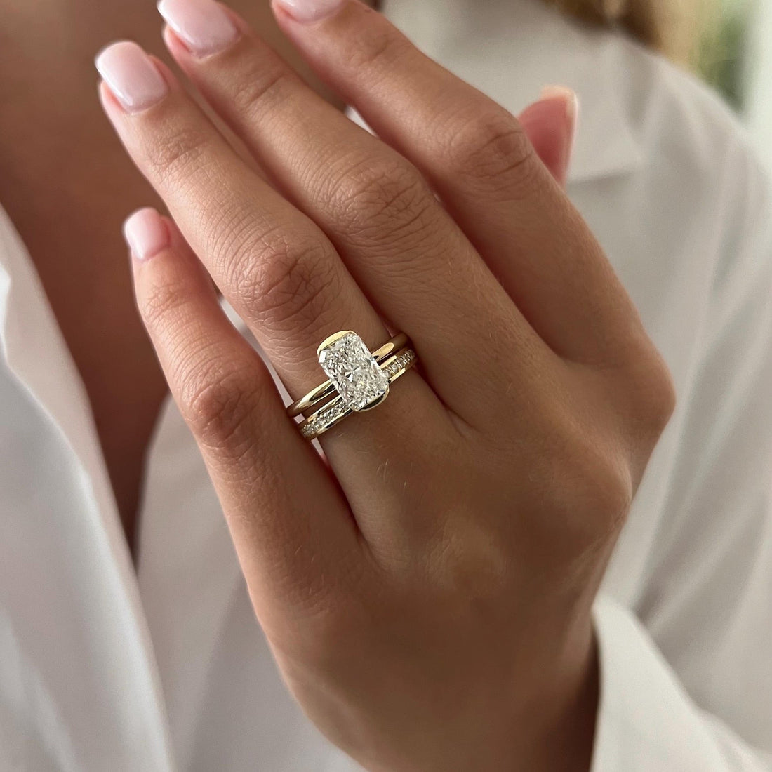 Elongated radiant moissanite half bezel bridal set in yellow gold worn on the hand