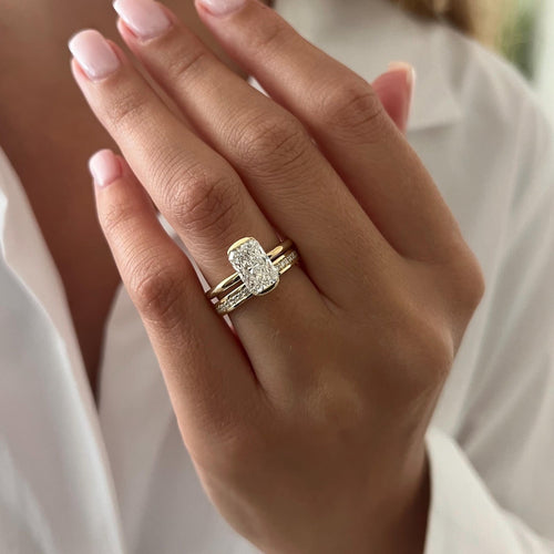 Elongated radiant moissanite half bezel bridal set in yellow gold worn on the hand