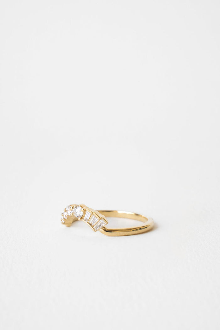 Curved moissanite band with baguettes and round stones, angled view