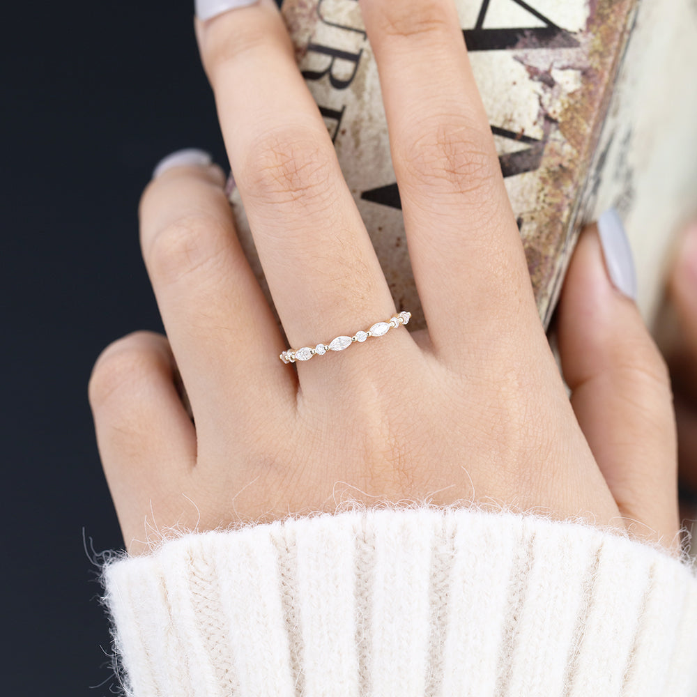 Round and Marquise moissanite half eternity wedding band, worn on the finger in yellow gold