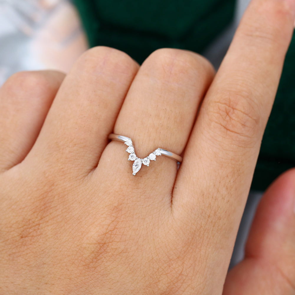 Round and Marquise moissanite v-shaped curved wedding band, worn on the finger in white gold
