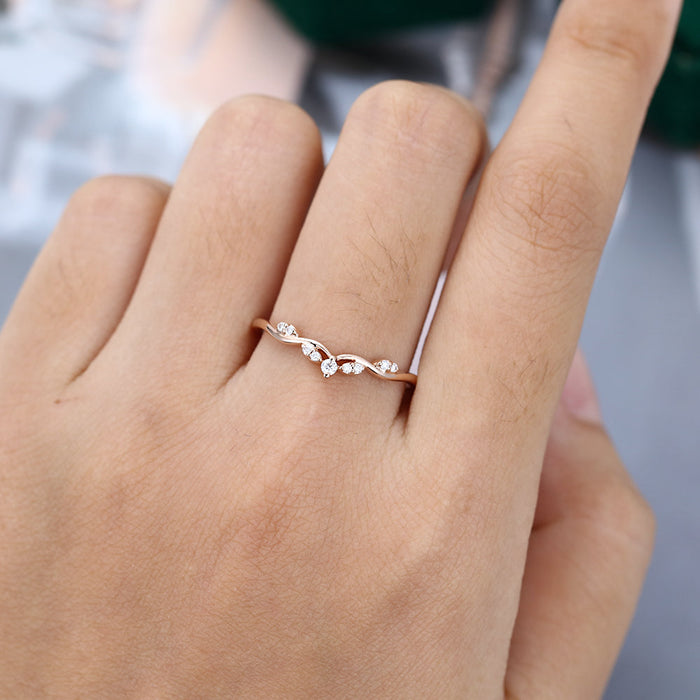 Round moissanite art deco crown curved wedding band, worn on the finger in rose gold
