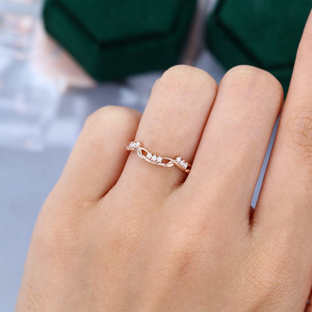 Round moissanite art deco leaf curved wedding band, worn on the finger in rose gold