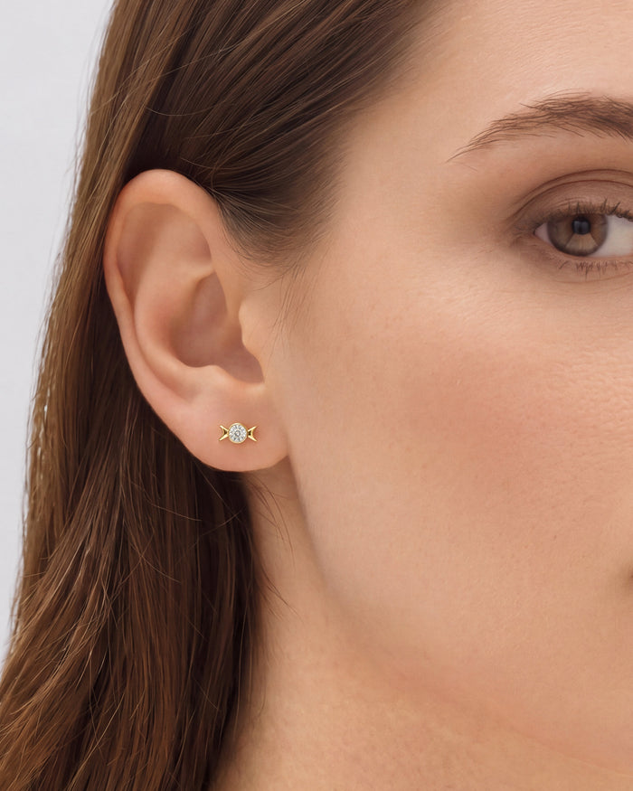 Model wearing round bezel moon phases lab grown diamond stud earrings, close up on the ear
