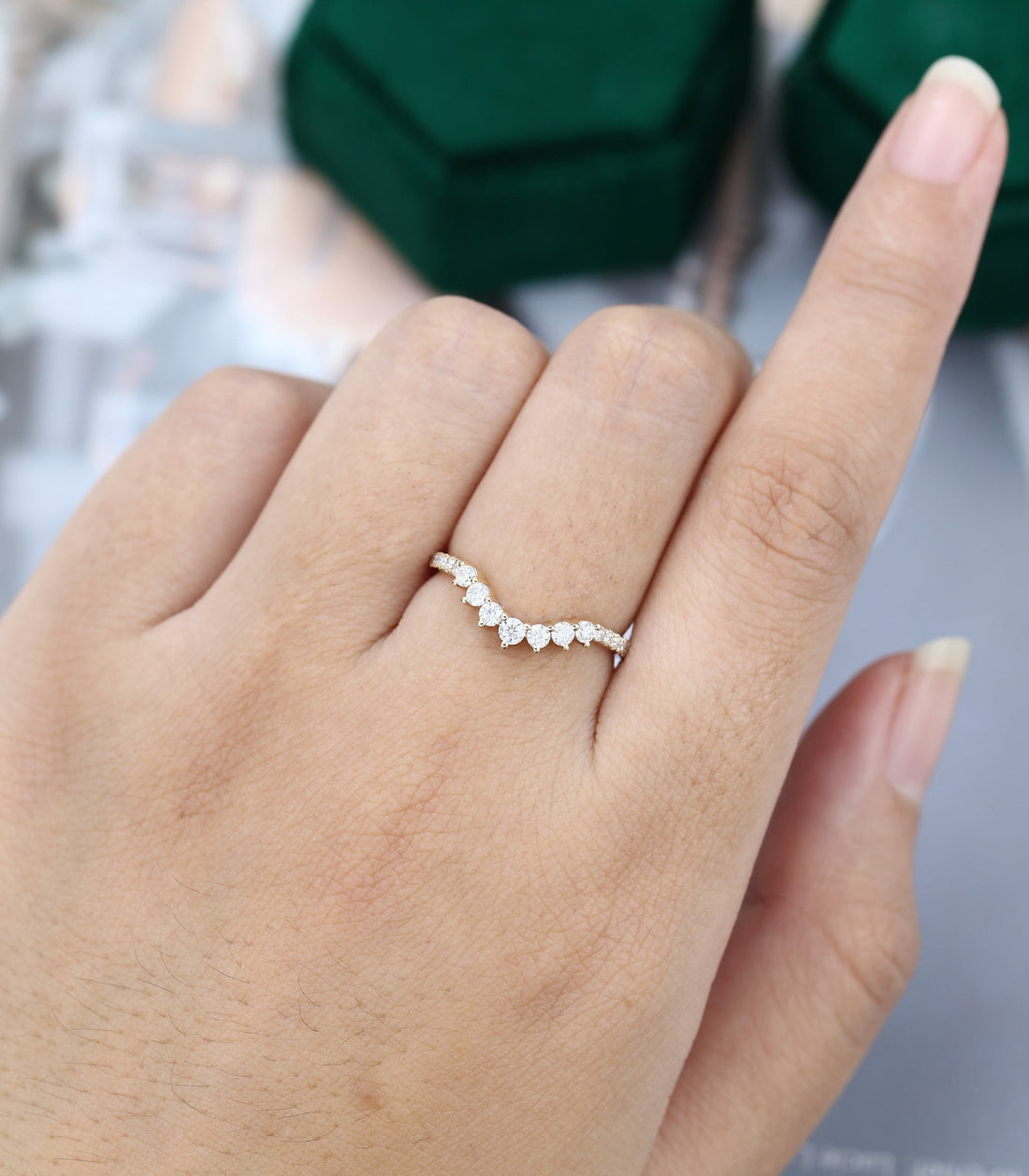 Round moissanite crown pave curved wedding band, worn on the finger in yellow gold