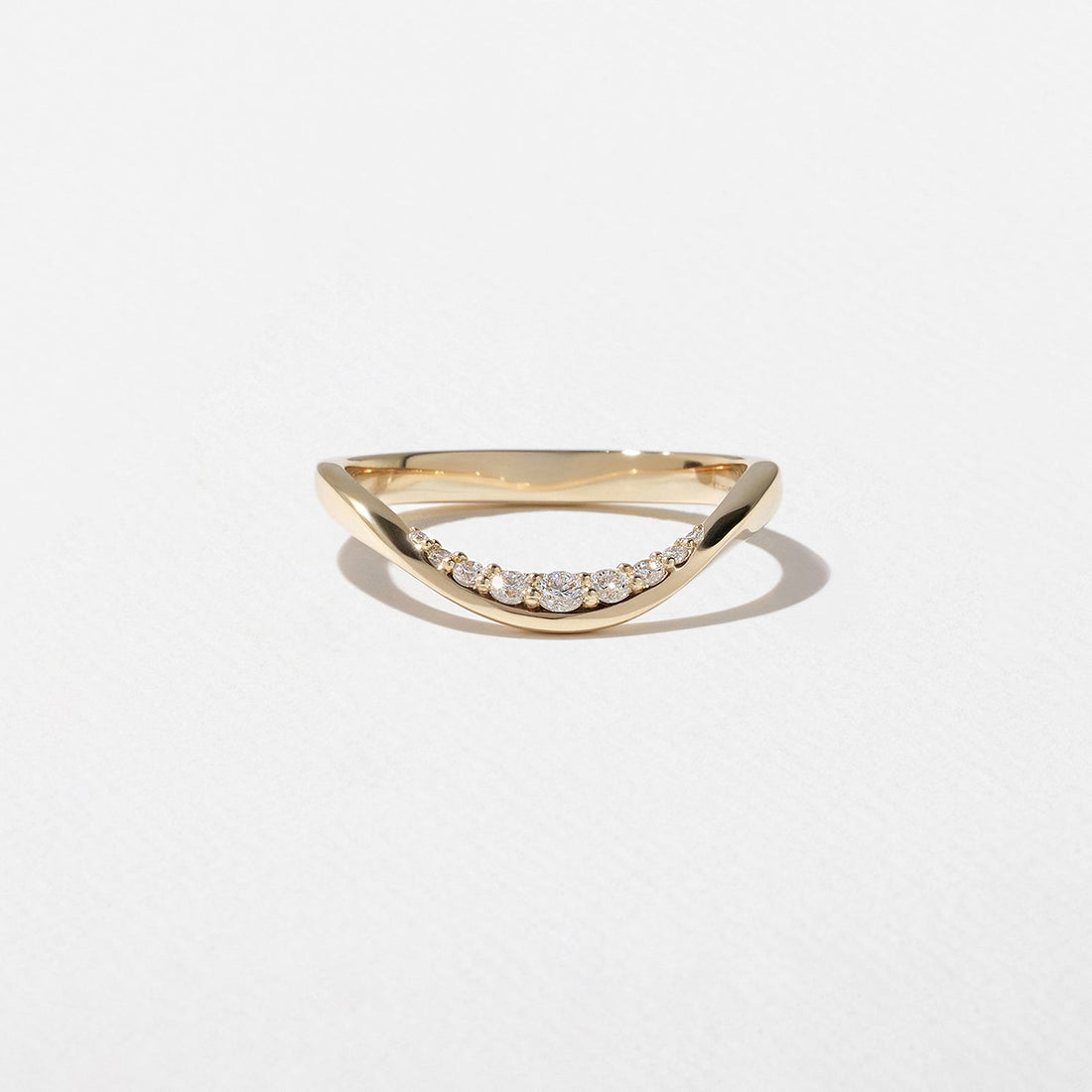 Round lab grown diamond curved wedding band in yellow gold front view