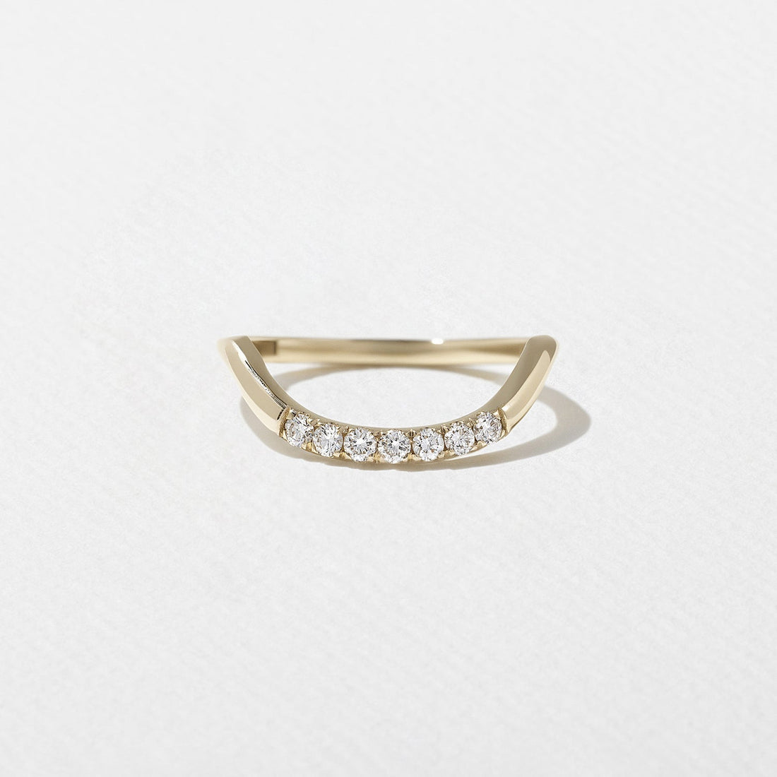 Round lab grown diamond curved wedding band in yellow gold front view