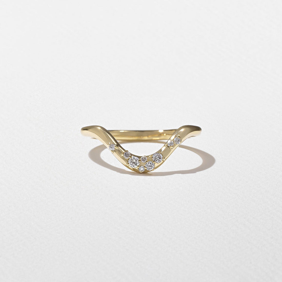 Round lab grown diamond curved scattered wedding band in yellow gold front view