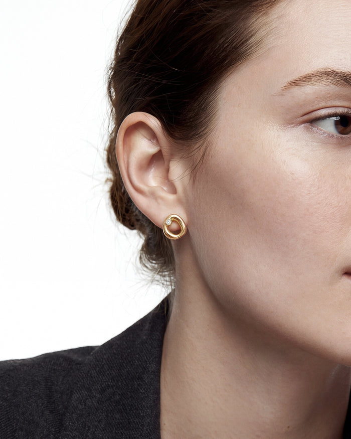 Model wearing round open circle lab grown diamond stud earrings, close up on the ear