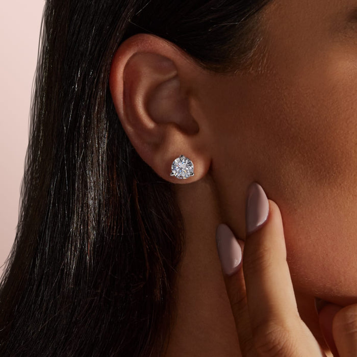 Round lab grown diamond martini set stud earring worn on the ear lobe of a woman with dark hair